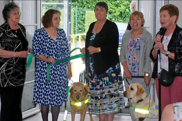ribbon cutting ceremony with members and guide dogs